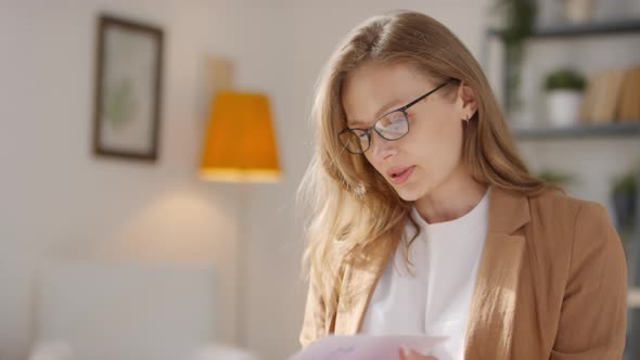 Female Teacher Looking through Planner at Home alt
