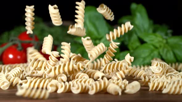 Super Slow Motion Shot of Fresh Fusilli Falling on Italian Decorated Wooden Table at 1000Fps alt