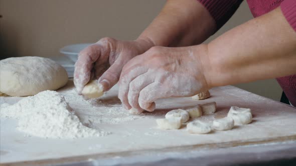 Closeup Hands of Senior Female is Preparing a Dough for Ravioli Side View