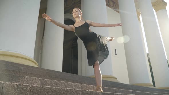 Wide Shot of Confident Redhead Young Ballerina Raising Leg Bending Forward alt