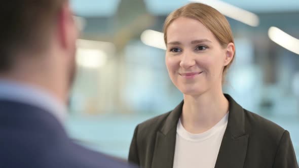 Young Businesswoman Talking with Businessman alt