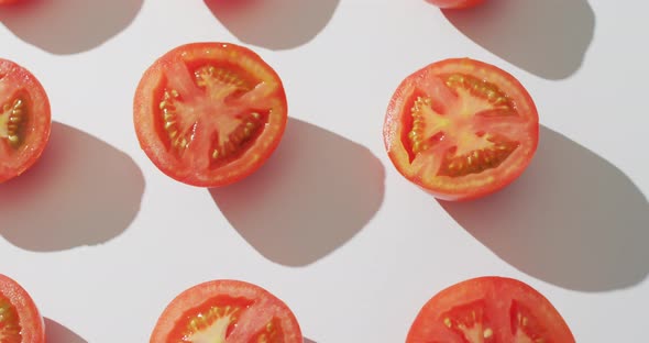 Video of fresh halved red tomatoes on white background alt