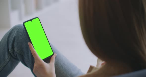 Young Girl Is Holding Smartphone With Green Screen At Evening Time. Smartphone in Hand, Static alt