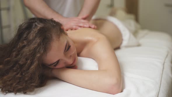 Professional Therapist Doing Healthy Massage on Back to Female Client