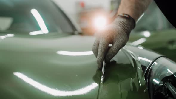 Process of Vinyl Wrapping a Car in Khaki Green Color Using Plastic Card