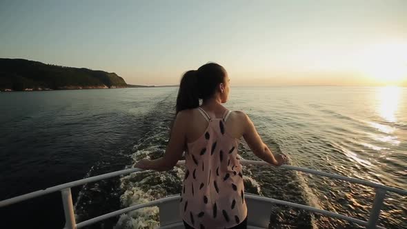 Rear View of a Beautiful Girl Standing on a Bow of the Ship Looking at the Beautiful Landscape of alt