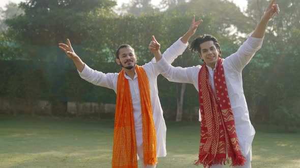 Indian men dancing and doing the bhangra in an Indian traditional outfit Kurta Pajama alt