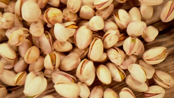 Super Slow Motion Shot of Fresh Roasted Pistachio Nuts Falling on Wooden Table at 1000 Fps alt
