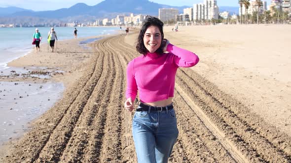 Dressed Young Woman Goes Along the Coastline and Smiling Slow Motion