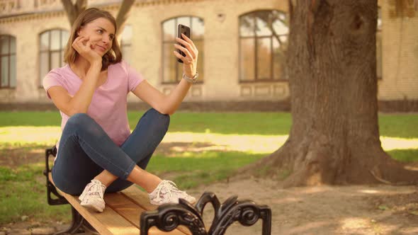 Young Woman Make a Photo on Mobile Near College alt