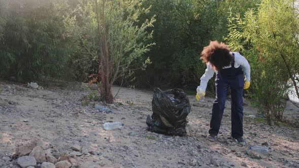 Adult Greenpeace Worker Volunteer Pickup and Collect Waste in Forest in Afternoon alt