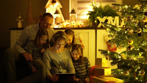 Family With Digital Tablet at Christmas Tree
