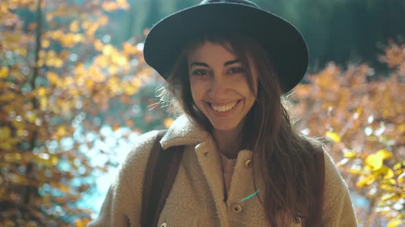Closeup Cheerful Ukrainian Woman Tourist on Trail in Fall Forest on Sunny Autumn Day alt