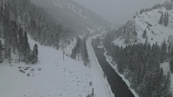 Aerial View of Curved River in the Snowy Mountains of During Winter Snowfall alt