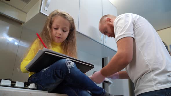 Dad with His 5 Years Old Kid Girl Draw in the Kitchen Casual Lifestyle Photo Series alt