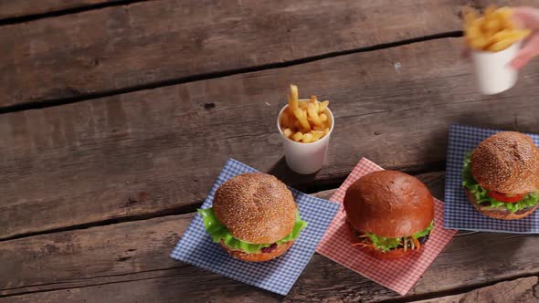 Woman's Hand Putting Fries Cup. alt