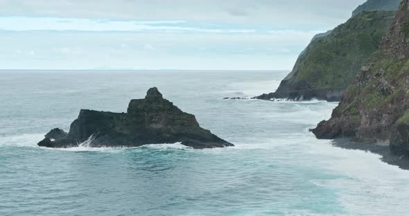 Steep Rocky Cliffs Covered with Moss and Vegetation Surrounded with High Tides alt