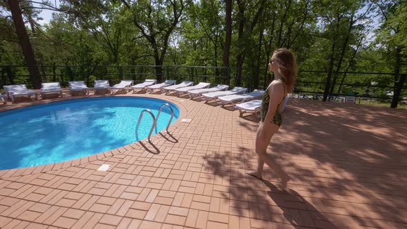 Young Woman Is Wearing Fashion Swimsuit Is Entering in Swimming Pool in Summer