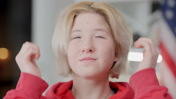 Closeup of Positive Asian Teen Girl with Pierced Nose and Problematic Skin Adjusting Hair alt