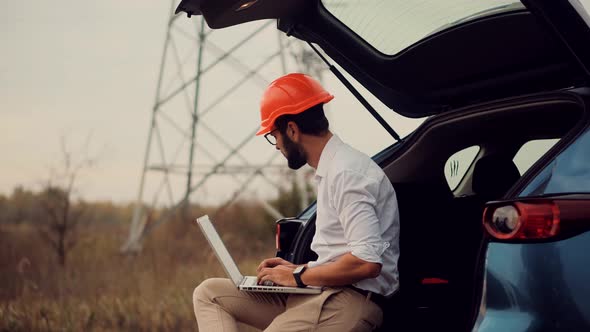 Constructor Inspect High Voltage Tower. Engineer In Hard Hat Maintenance Electricity Transmission. alt