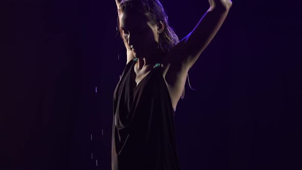 A Slender Blonde is Dancing Bachata Among the Raindrops and Splashing Water alt