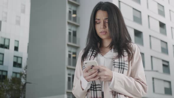 Businesswoman Texting on Smartphone at Street. Focused Girl Using Mobile Phone alt