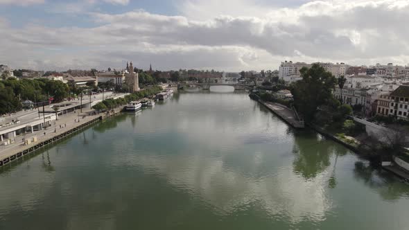 Torre del Oro military watchtower on Guadalquivir river bank; drone push in