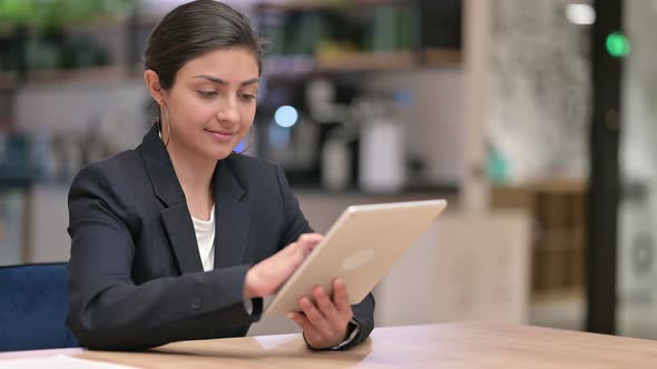Serious Professional Indian Businesswoman Using Tablet in Cafe  alt
