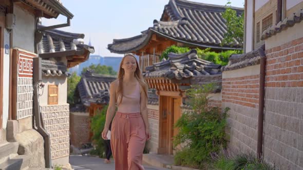 Young Woman Visits the Busy Touristic Historical Street Bukchon Hanok Village in a Center of Seoul alt