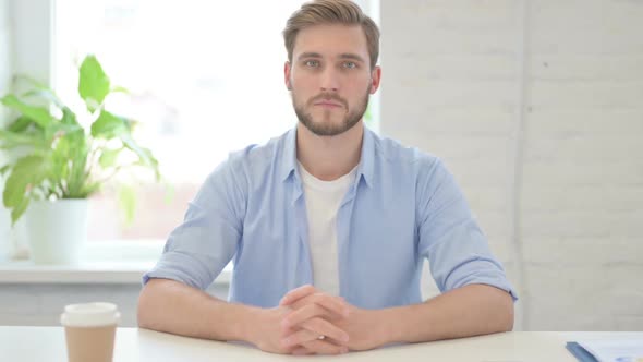 Young Creative Man Looking at Camera in Modern Office alt