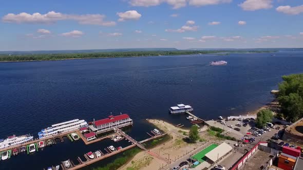 Coastline of Wide River with Boat Dock Aerial View at Summer Big Motorship is Moving