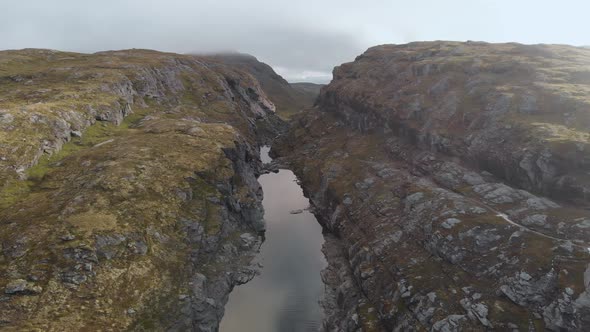 River flowing through steep canyon walls in Norwegian highlands, aerial view alt
