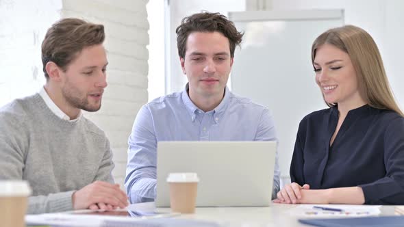 Cheerful Creative Team Doing Video Chat on Laptop alt
