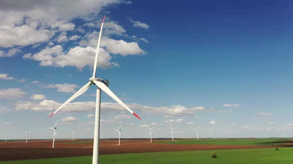 Wind Turbine Power Generator Farm at Beautiful Pure Blue Sky and Green Grass Background alt