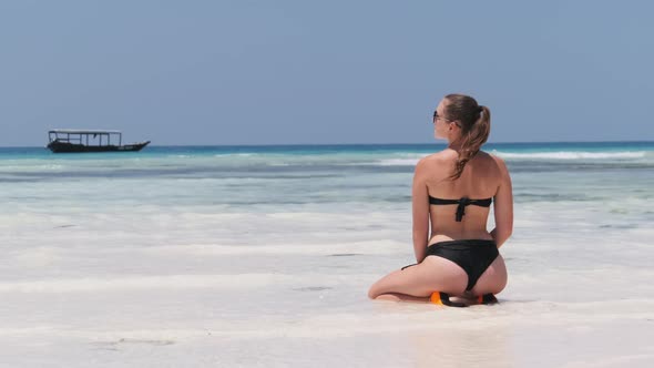 Young Woman in Black Bikini Tans in Lotus Pose on Paradise Sandy Beach By Ocean alt