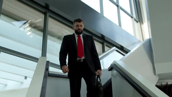 Cute Caucasian Man Chief Executive Officer Descends the Stairs in the Office of a Modern Company alt