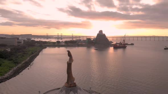 Aerial shot of Kun Iam statue and Macau Science Centre in front of stunning sunrise alt