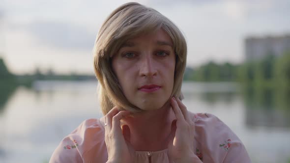 Headshot Portrait of Trans Woman Looking at Camera As Mirror Touching Hair and Smiling alt