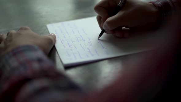 Man’s hands writing vintage letter on white paper on brown wooden table.  Grooms vow, 