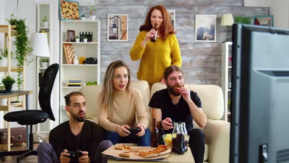 Young Man Eating Chips While Playing Video Games alt