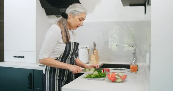 Elderly Woman Chopping Salad Kitchen