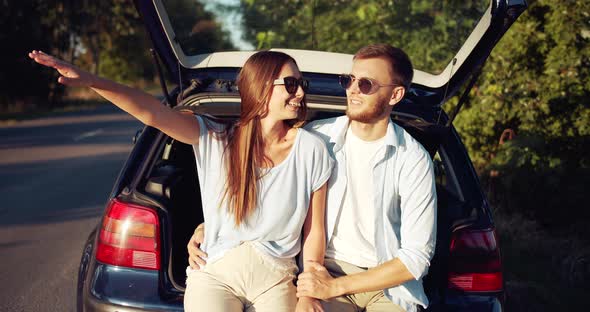 Couple Sitting in Car Trunk and Relaxing