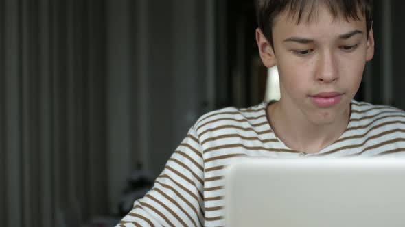 teenager surf the internet for a laptop at home