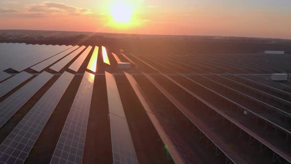 Aerial Drone View of Large Solar Panels at a Solar Farm at Bright Sunset in Early Winter alt