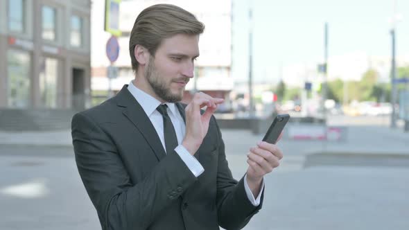 Businessman Celebrating Online Success on Smartphone Outdoor alt