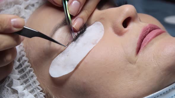 in a Beauty Salon a Woman Undergoes an Eyelash Extension Procedure alt