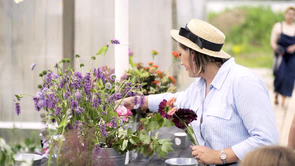 Woman in Hat Make Fresh Flower Bouquet on Table