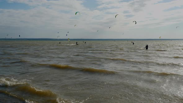 Kitesurfers ride on waves.