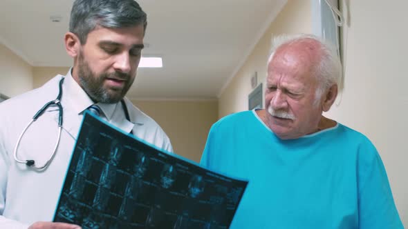 Doctor examining X-ray picture with old patient