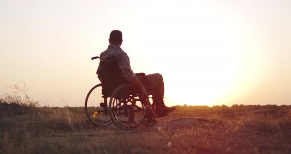 Soldier Sitting in a Wheelchair on a Meadow alt